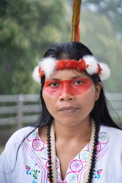 Nemonte Nenquimo wearing a red and white feather headband and red face paint